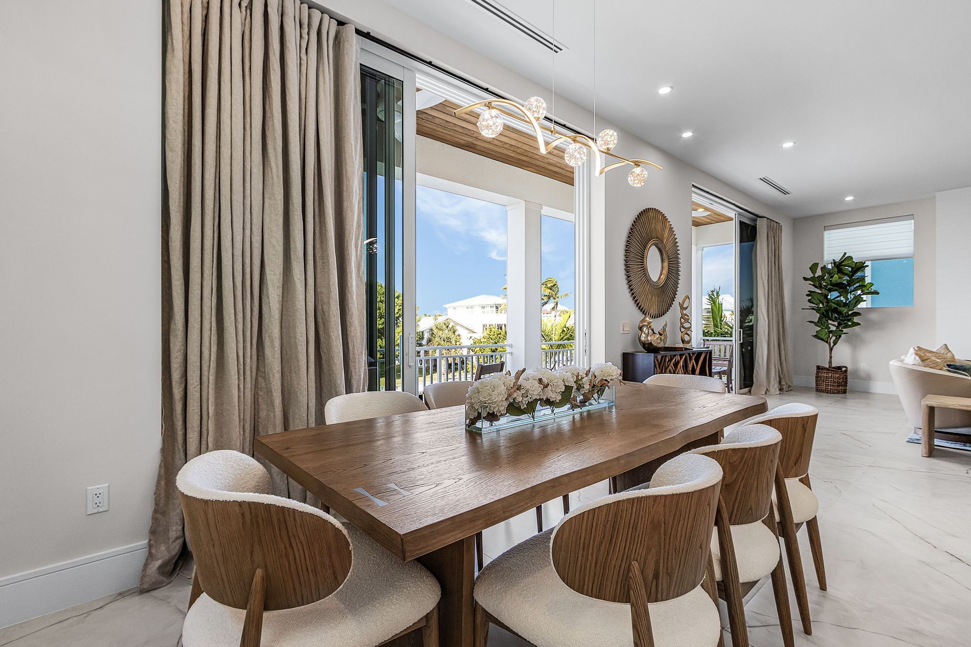 Dining room with a long wooden table, six chairs, and large sliding doors.