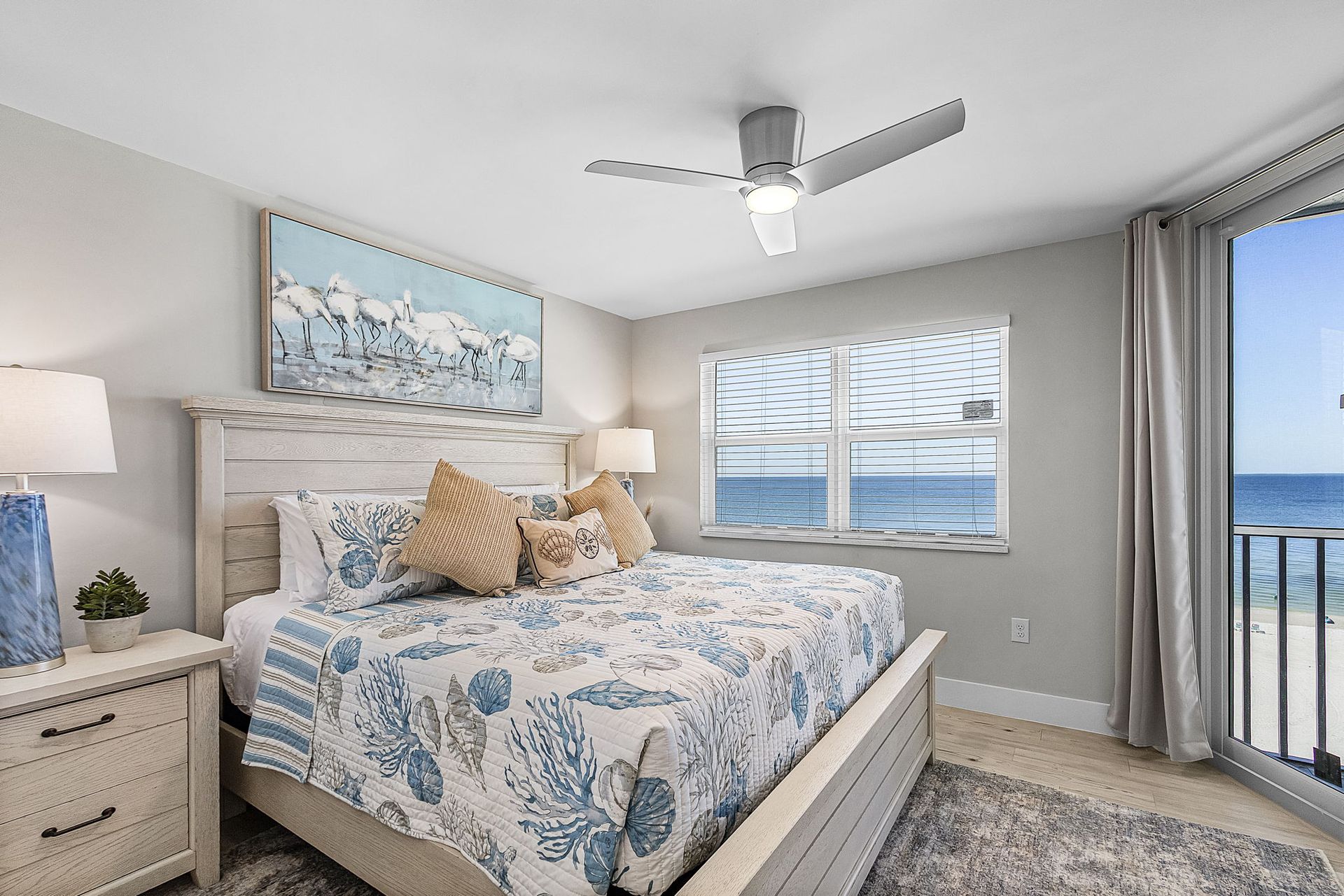 Bedroom with a king bed, ocean view, and beach-themed decor.