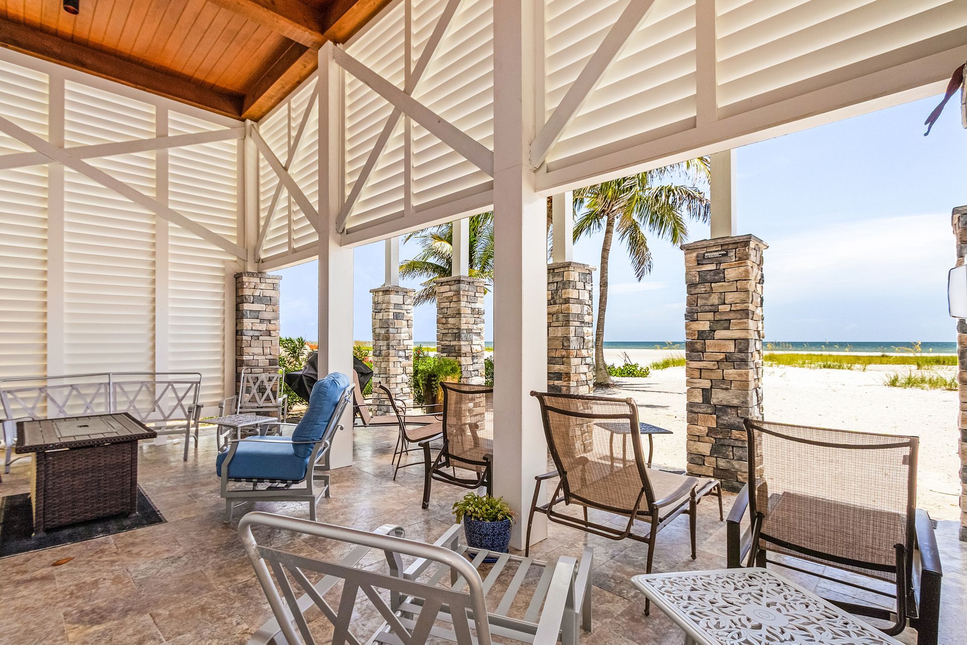 Covered patio with lounge chairs and a grill overlooking the ocean