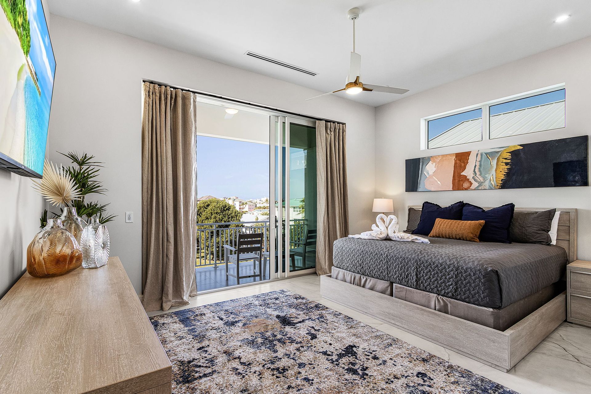 Bedroom with bed, balcony view, and neutral colors.