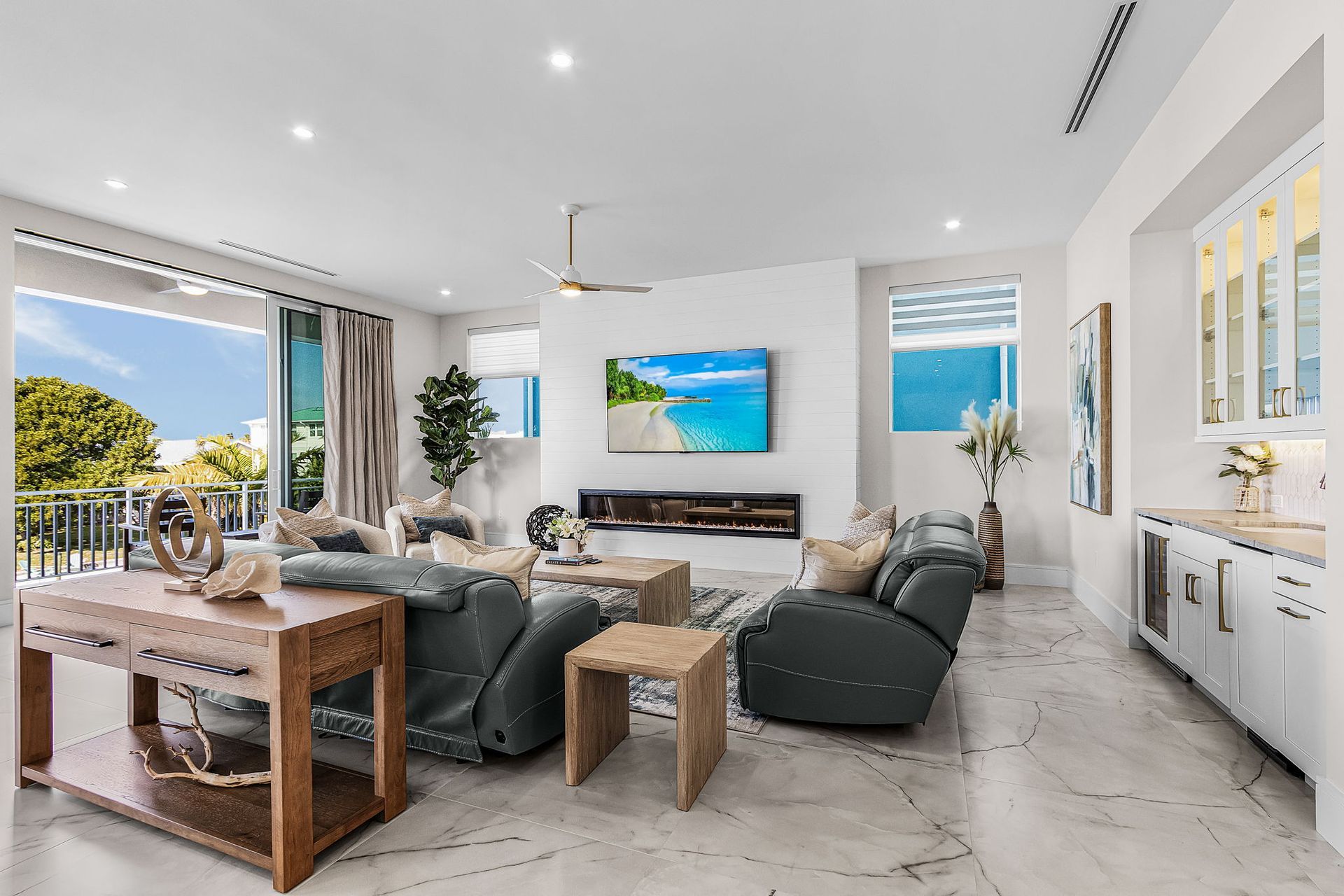 Spacious living room with ocean view, modern furniture, fireplace, and bar area.