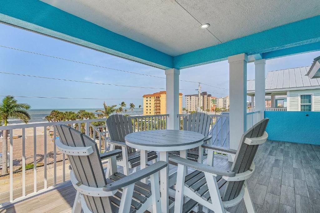 Balcony with a table and chairs, overlooking a waterfront view with blue and white accents.
