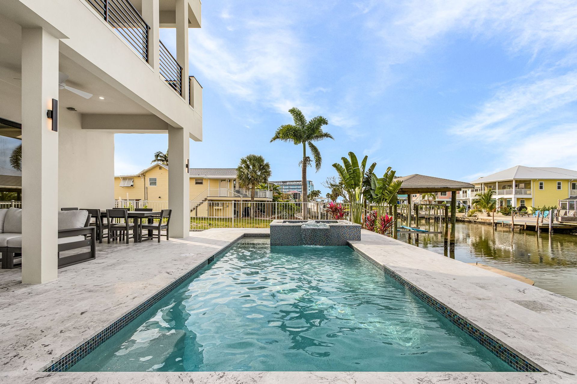 Poolside view of modern house with pool and canal.