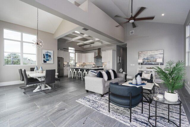 Modern, open-concept living space with gray walls, dining area, and living room with a gray rug and blue accents.