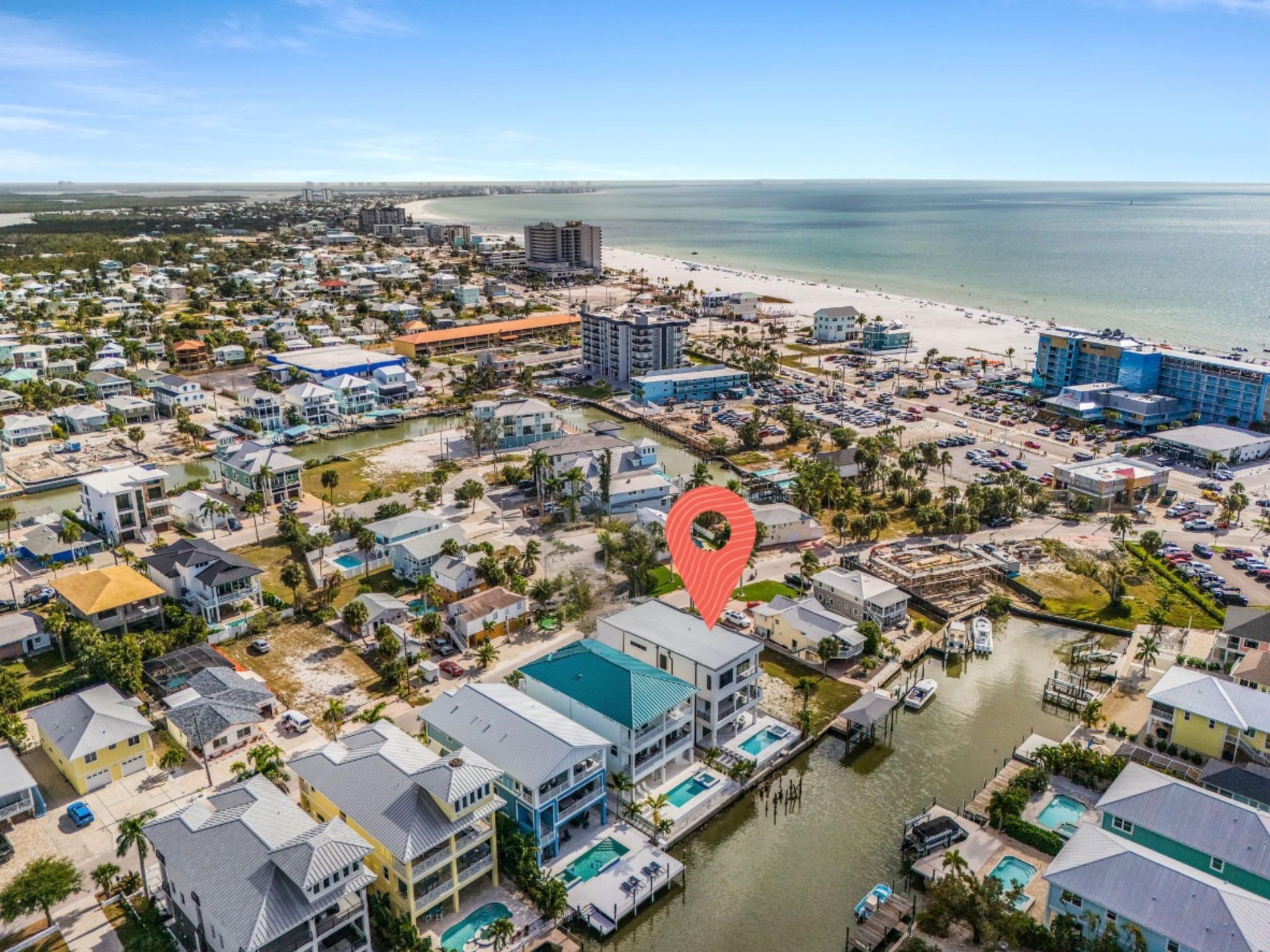 Aerial view of coastal homes and beach, with a location pin marker.