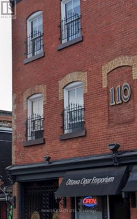 Red brick building with black awning and