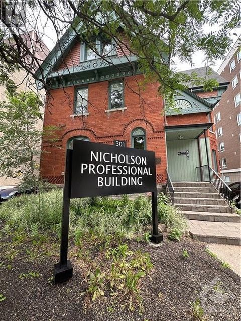 A sign in front of a brick building that says nicholson professional building