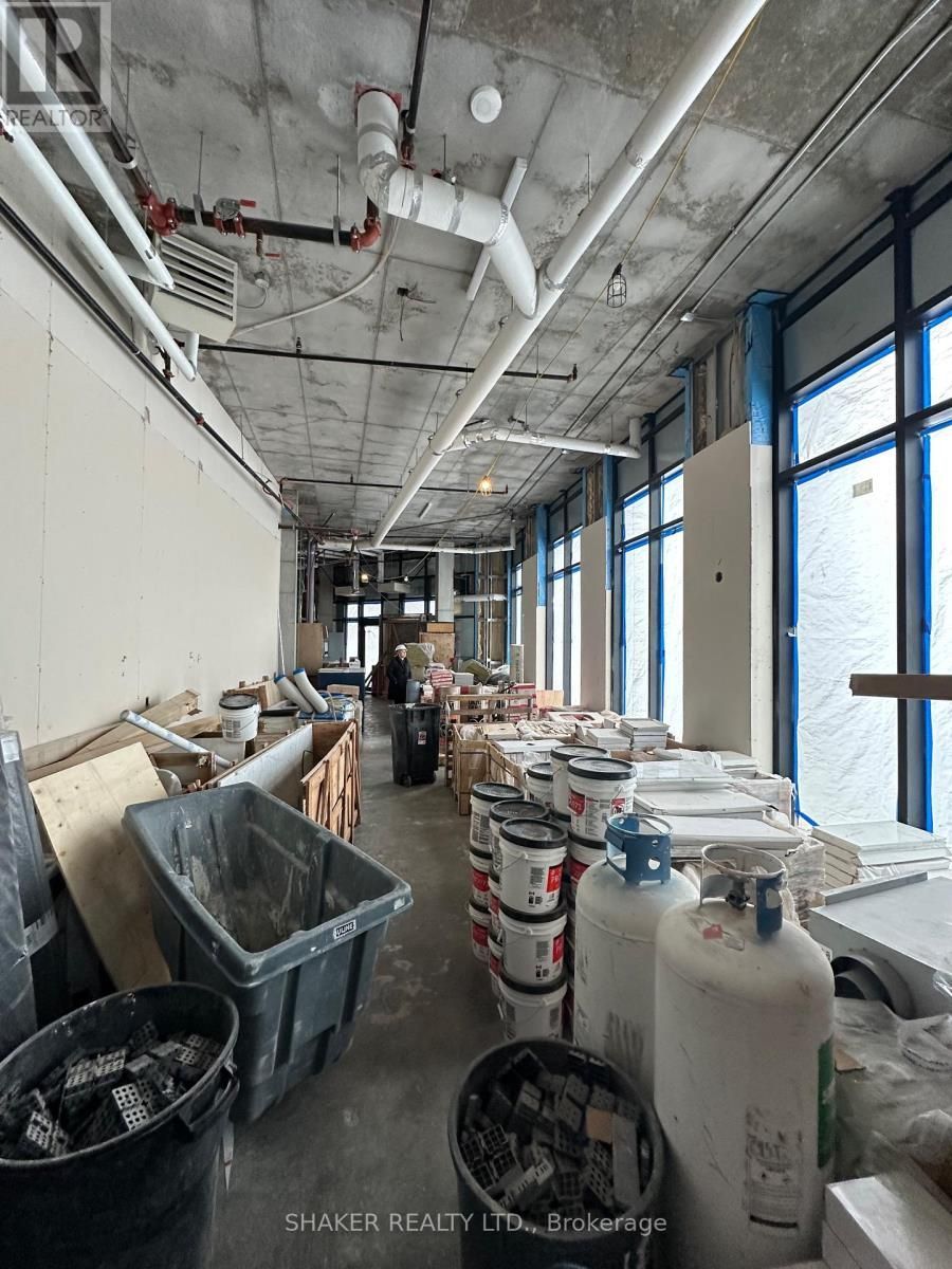 Construction site interior. Paint cans, debris, unfinished walls, and window with a view.