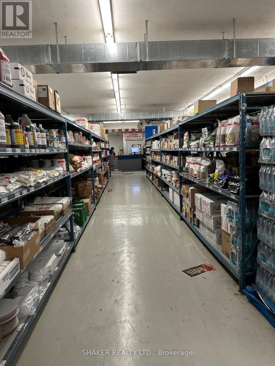 Warehouse interior with shelves stocked with various products; long aisle.