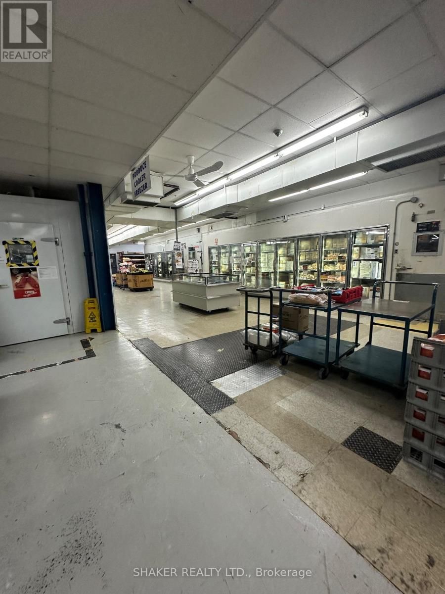 Warehouse interior with metal shelving filled with packaged goods, under fluorescent lighting.