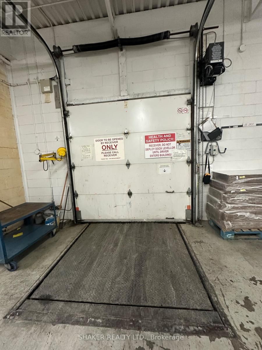 Loading dock with a closed garage door and a lift platform.