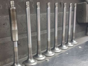 A row of metal valves are lined up in a row