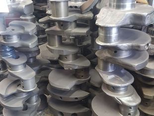 A bunch of crankshafts are stacked on top of each other.