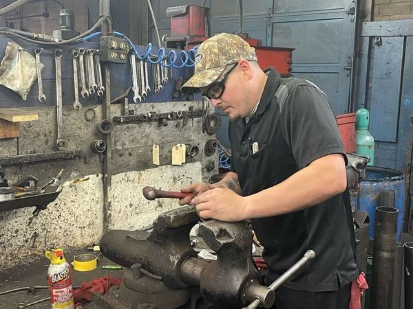 A man is working on a machine in a garage.