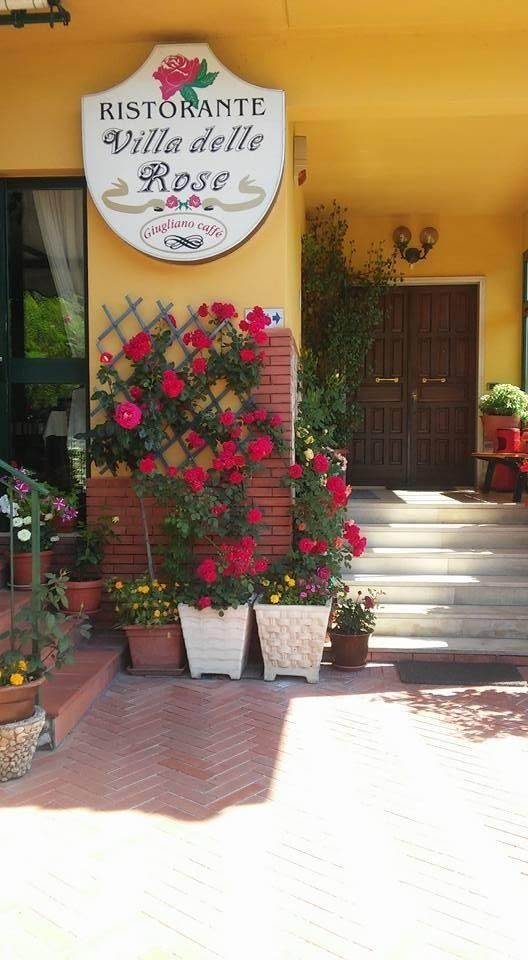 ingresso di un ristorante con fiori e insegna