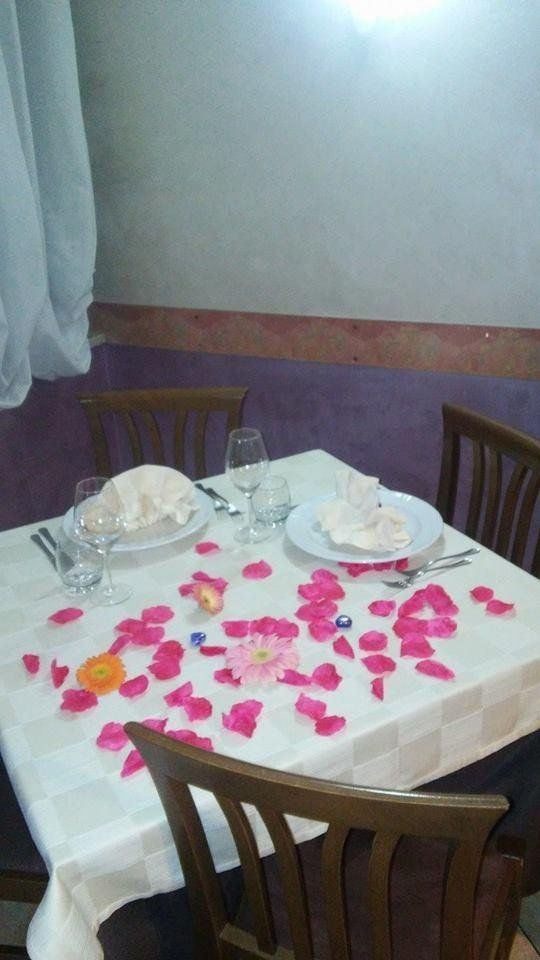 tavolo di un ristorante con petali di rose rosa