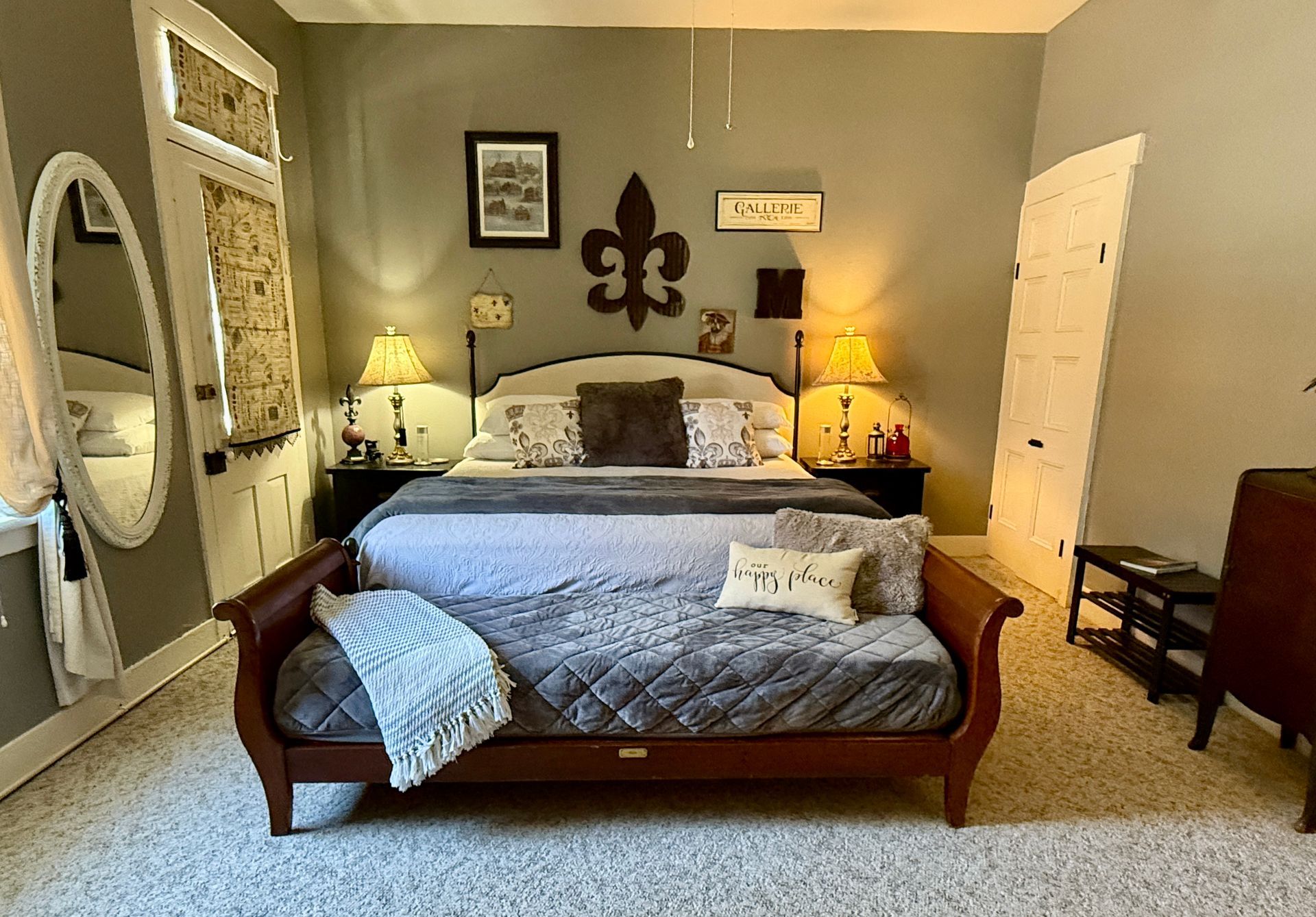 Bedroom with gray walls, bed with dark red frame, decorative items.