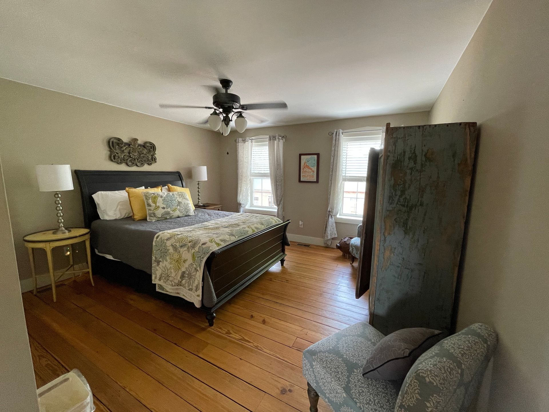 Bedroom with a bed, dresser, chair, and wood floors.