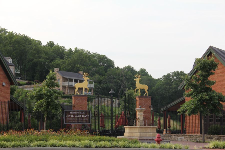 Entrance to Sugarleaf Estates with golden deer statues on brick pillars.