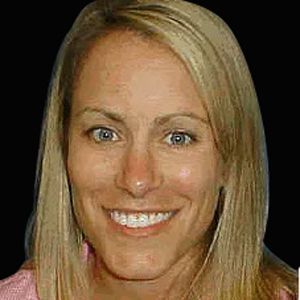 A smiling doctor in a lab coat with a stethoscope around his neck.