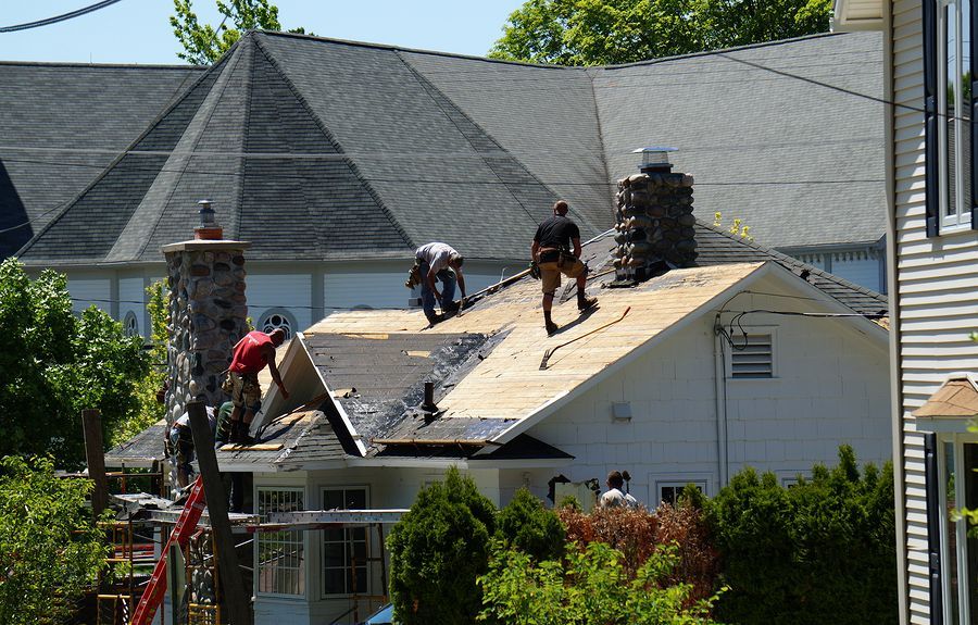 a couple of men working on a roof