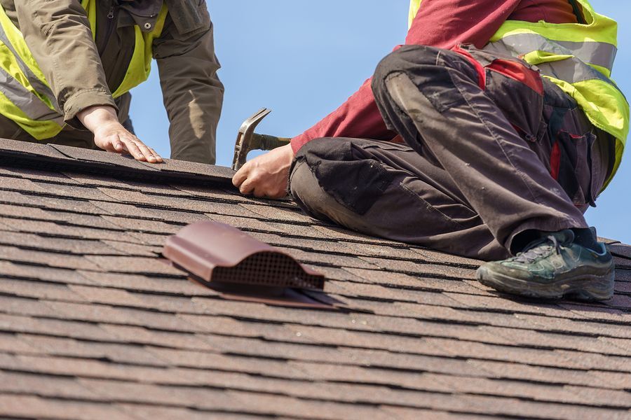 a couple of men working on a roof