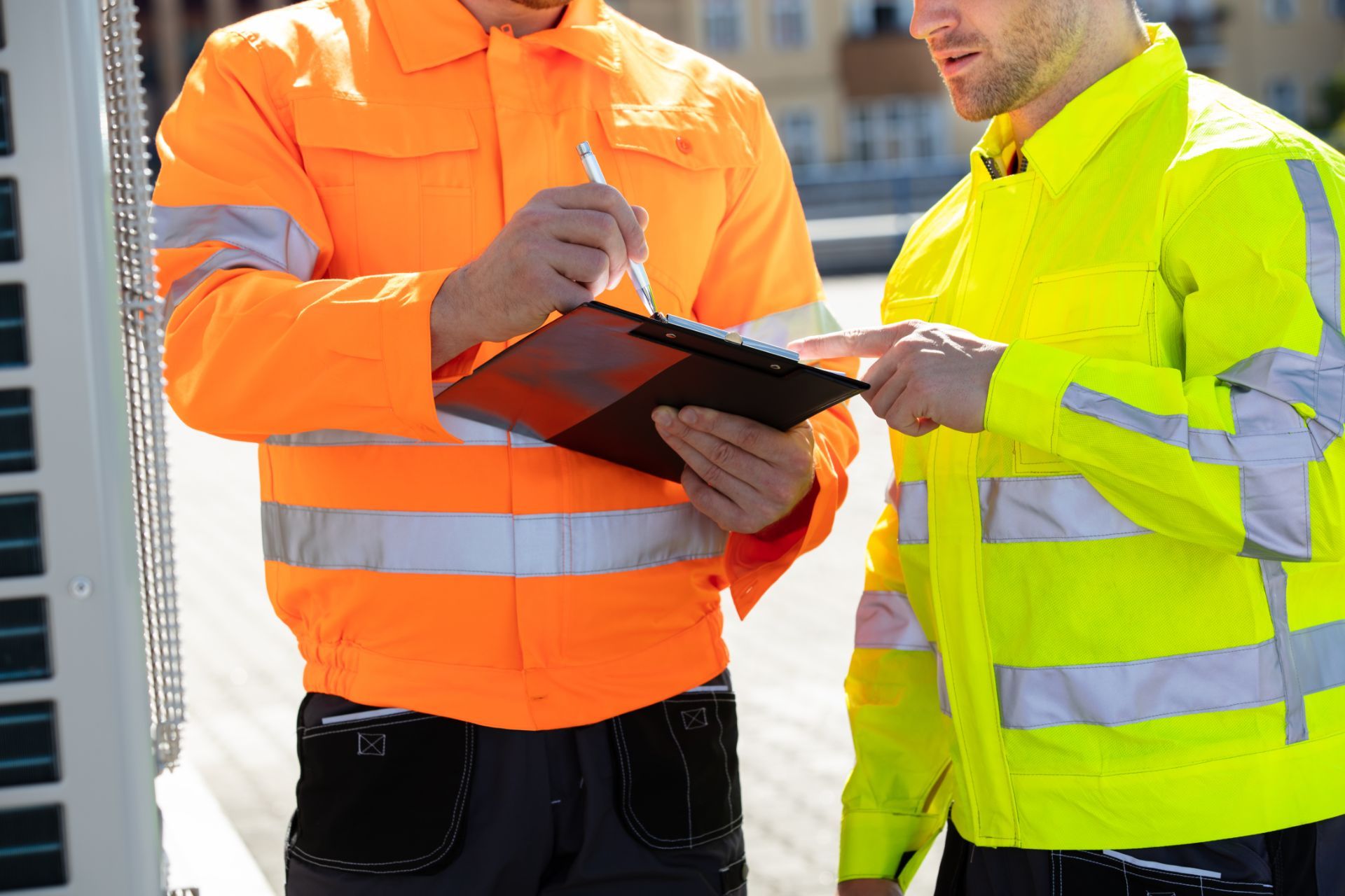 Men in safety vests looking at clipboard