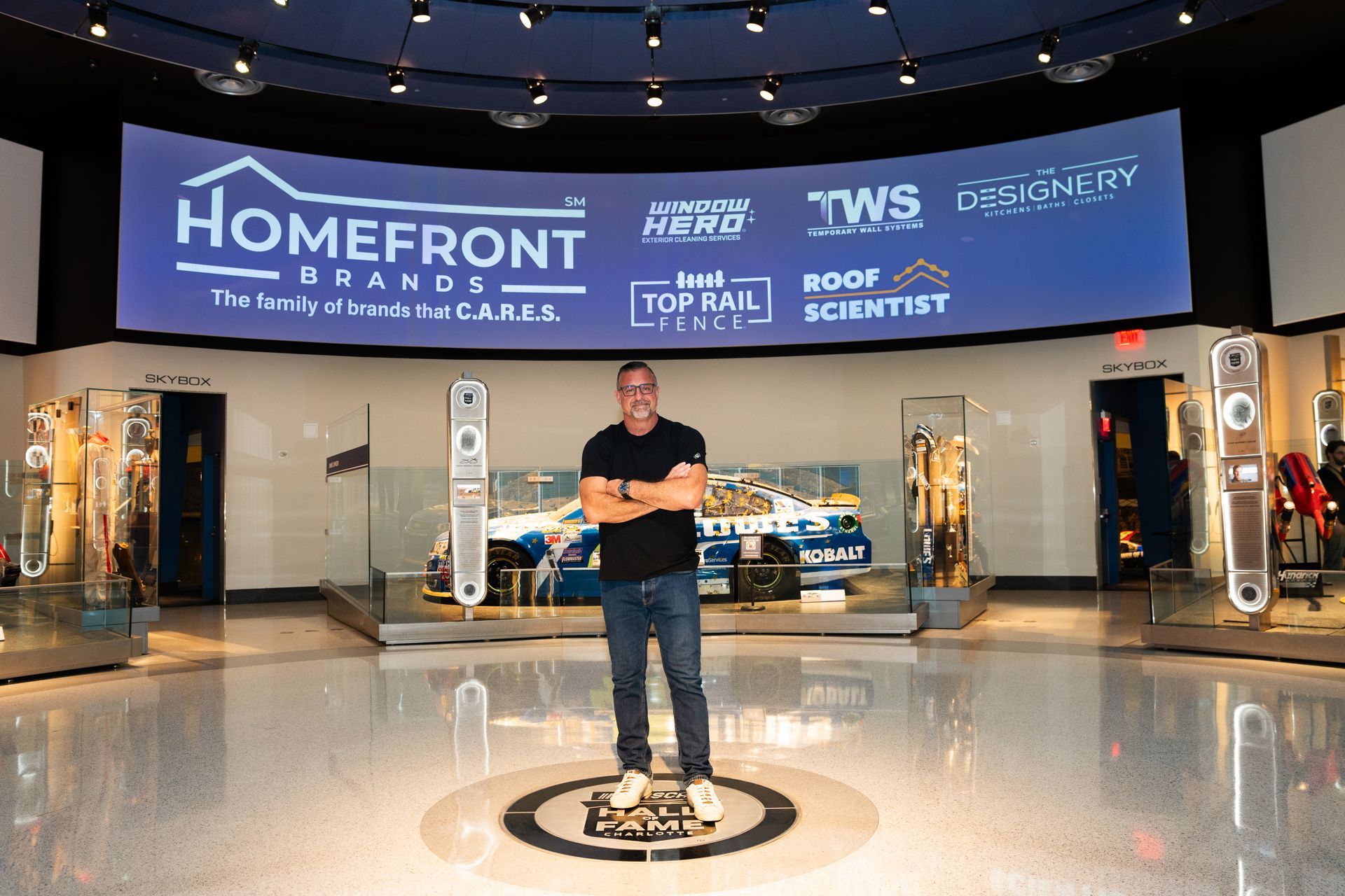 A man is standing in front of a large sign that says homefront
