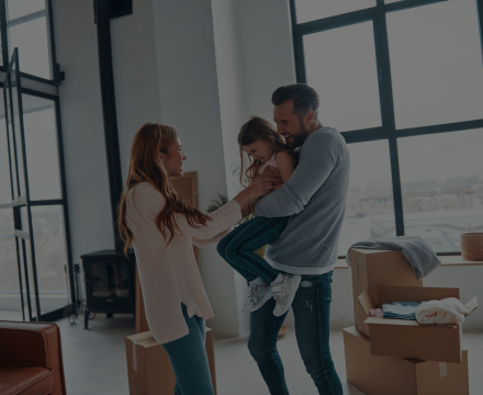 A man and woman are holding a little girl in their living room.