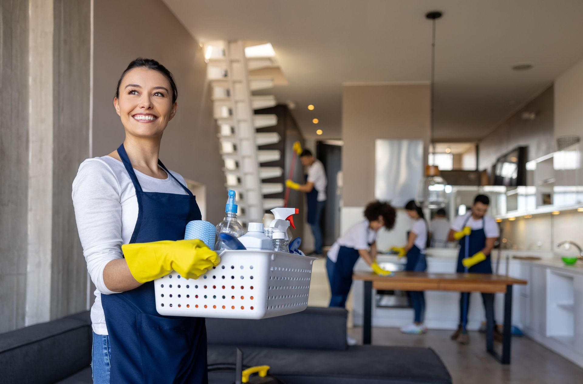 A woman is cleaning a room with a spray bottle and a cloth.
