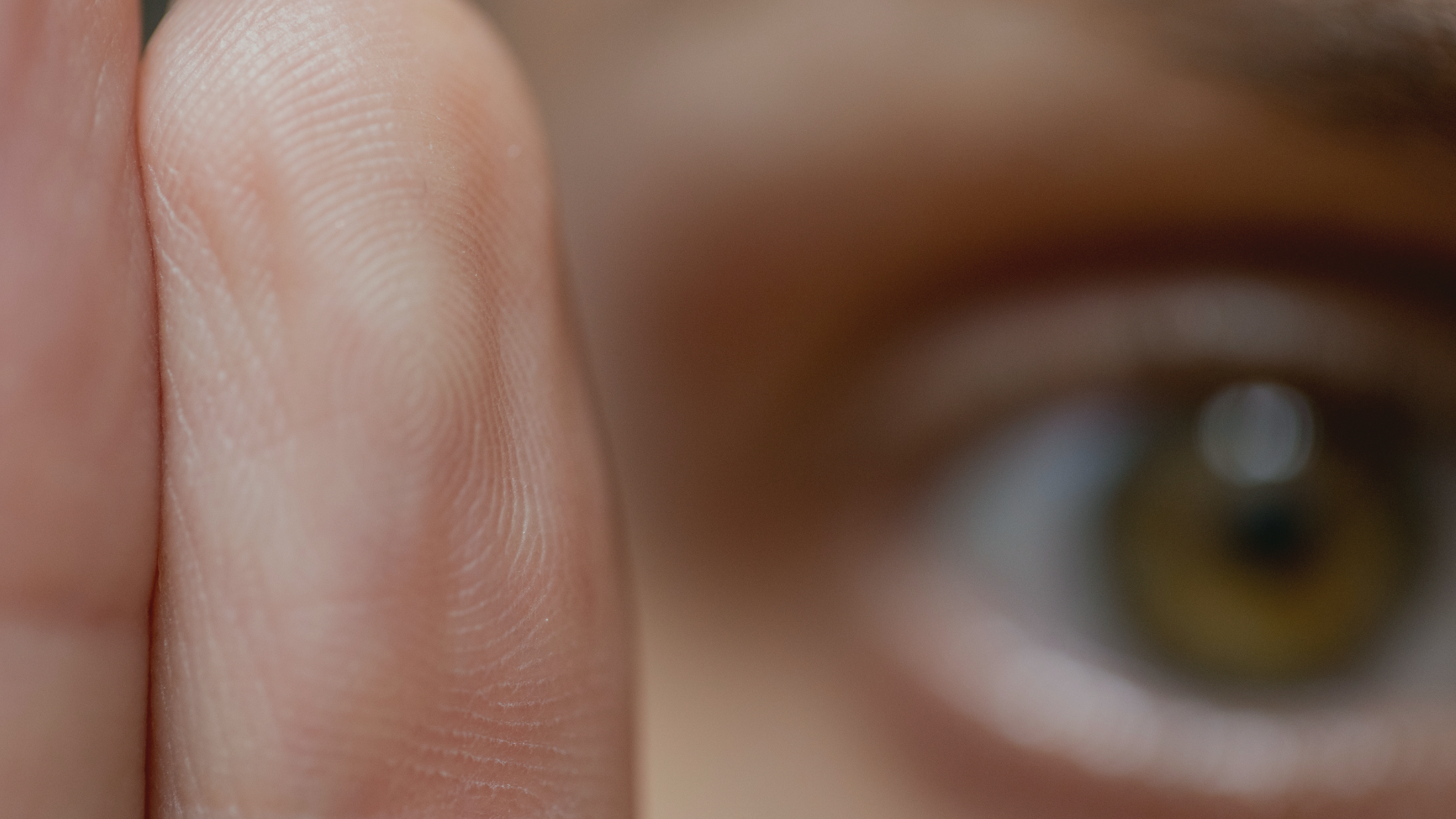 a close up of a person 's eye and a finger representing EMDR therapy at Healing Our Trauma KC