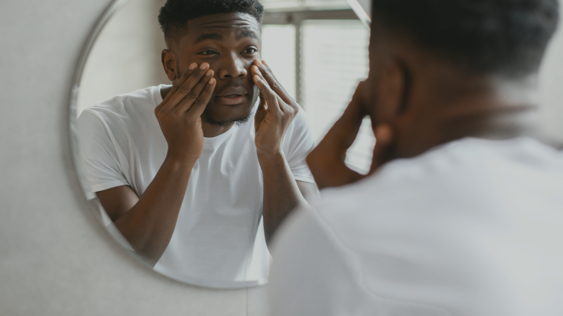 a man is looking at his face in a mirror representing adjustment disorder at Healing Our Trauma KC