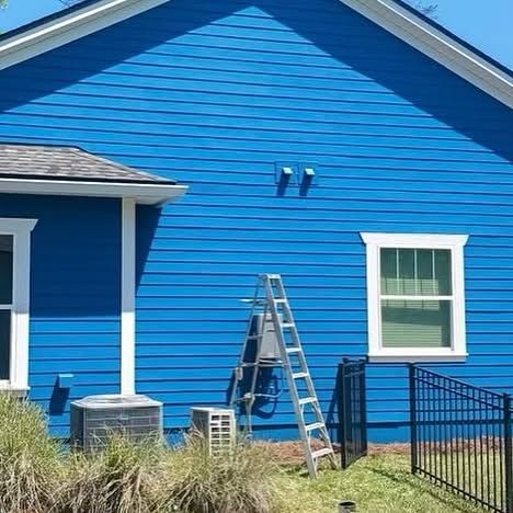 A blue house with a ladder in front of it.