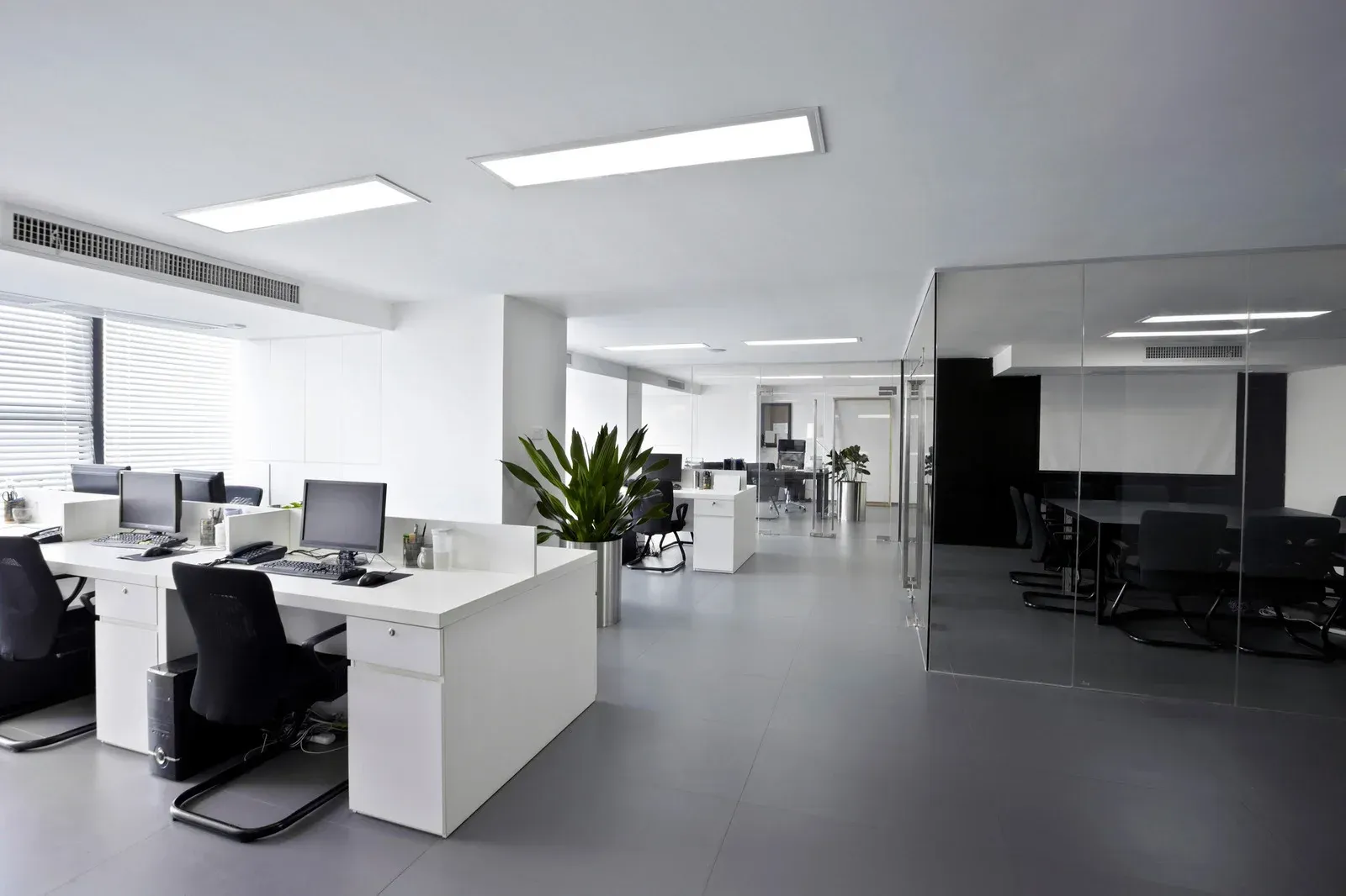 An empty office with a lot of desks and chairs.