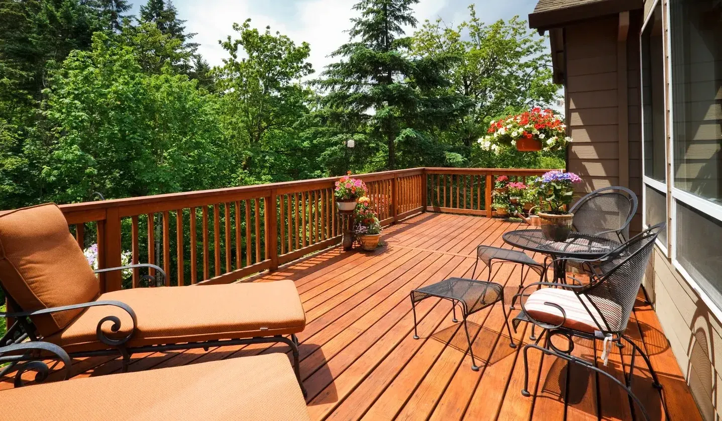 A large wooden deck with chairs and a table