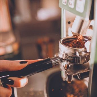 Una persona está moliendo café en una máquina de café.