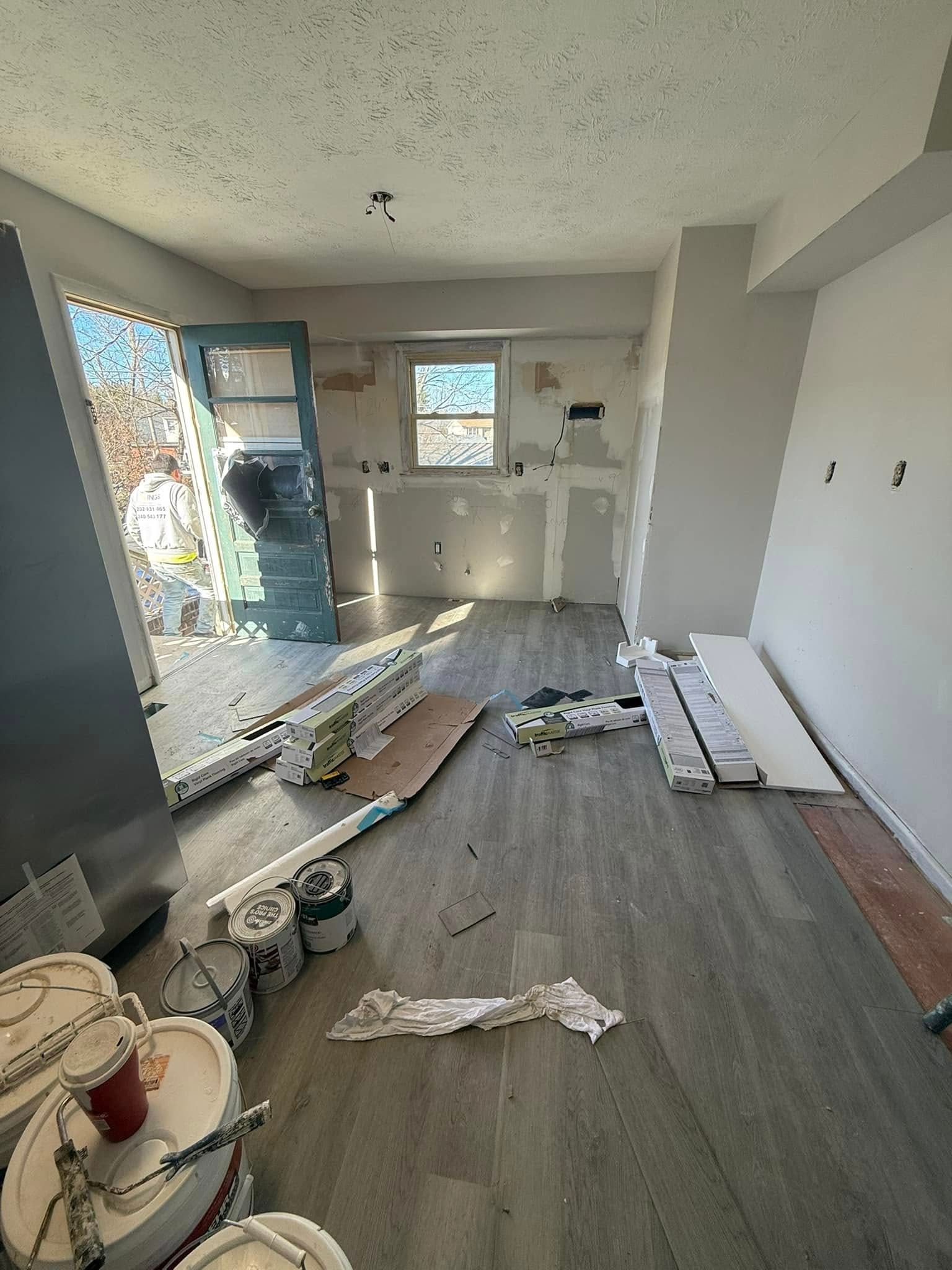 Room under construction, with exposed drywall, flooring, and construction materials.