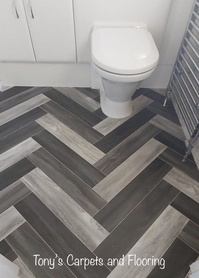 herringbone effect  vinyl flooring in a gray, silver and black coulors, that is R10 slip resistant with a cushioned backing for extra comfort lino, water proof flooring
