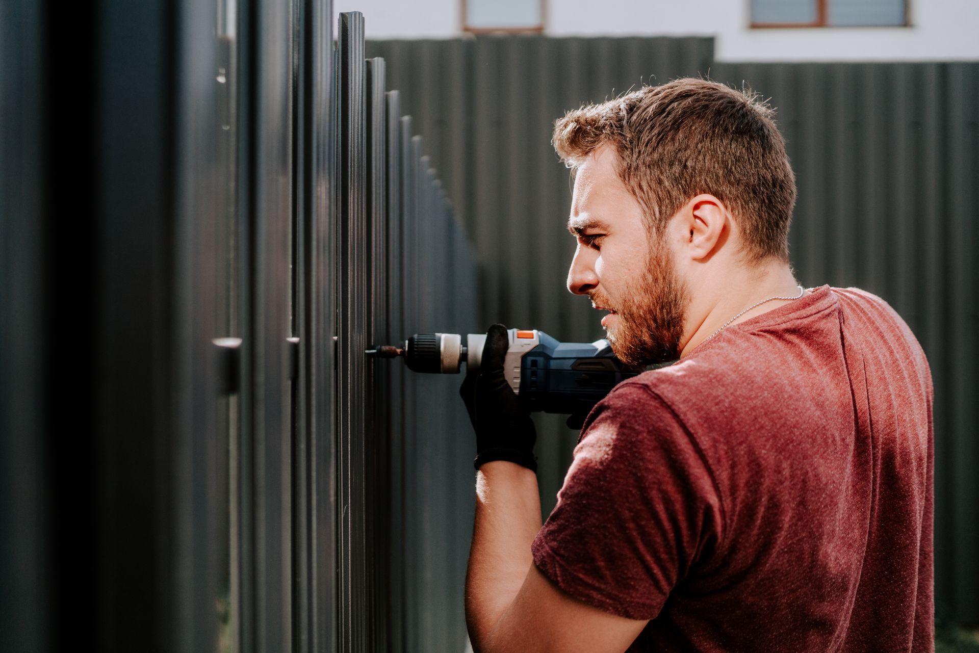 A man is installing a metal fence.