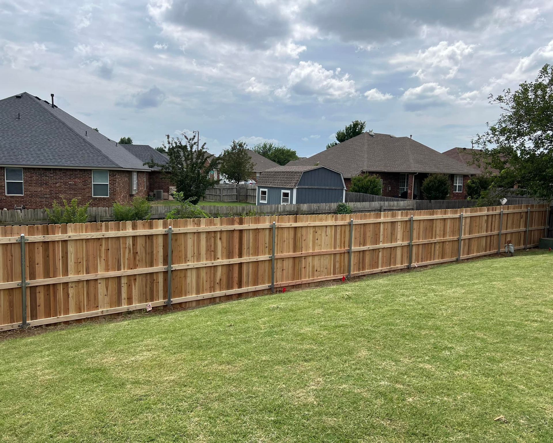 A wooden fence with a gate in the backyard of a house.