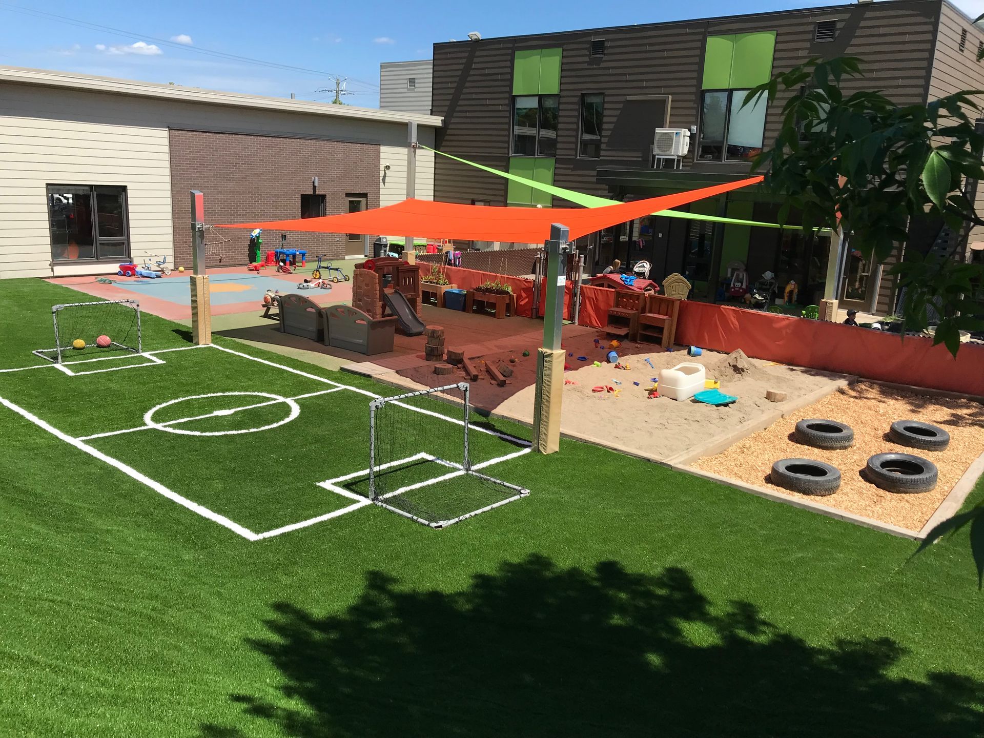 Une aire de jeux avec un terrain de football et un bâtiment en arrière-plan.