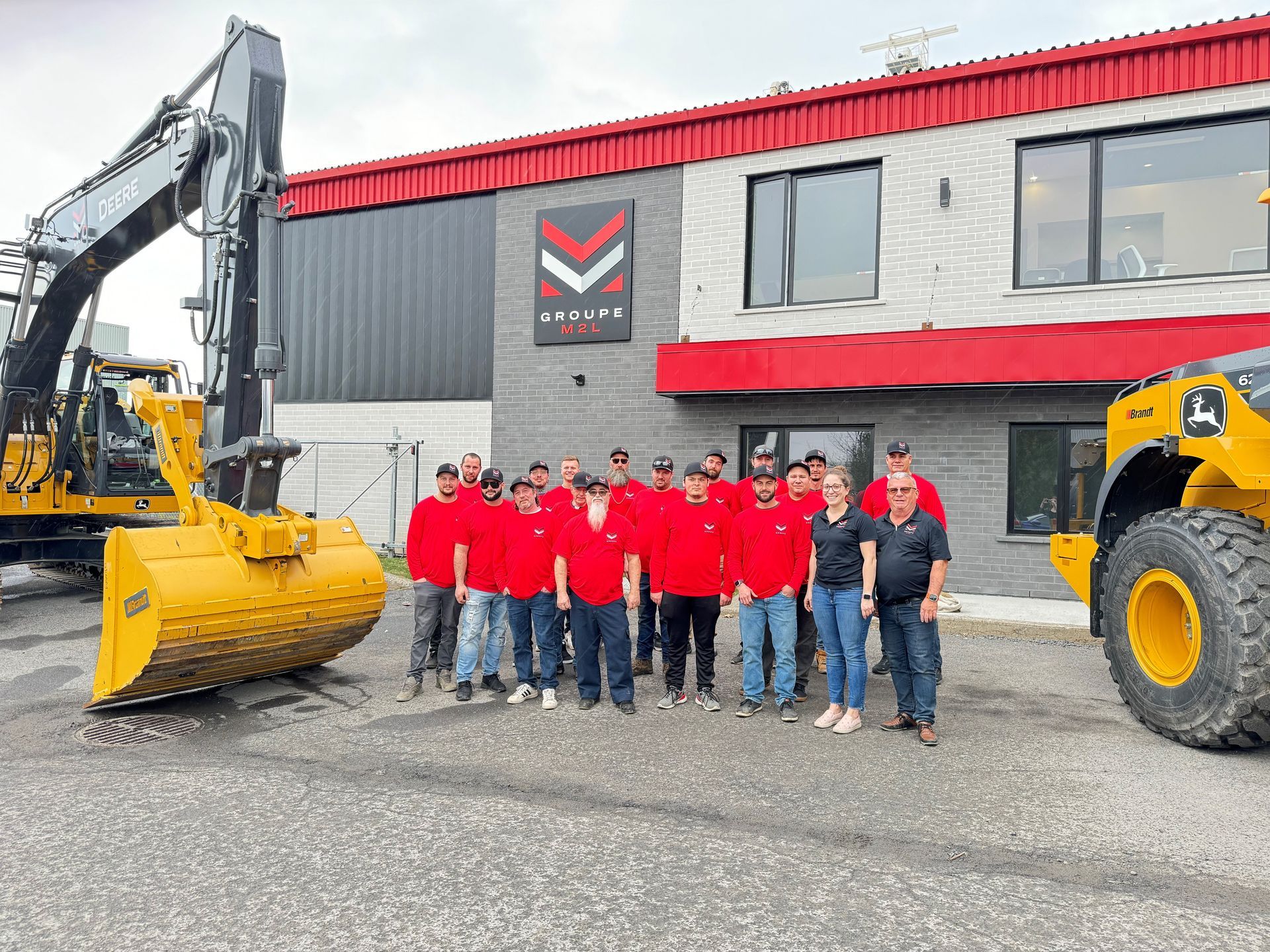 Un groupe de personnes pose pour une photo devant un immeuble.