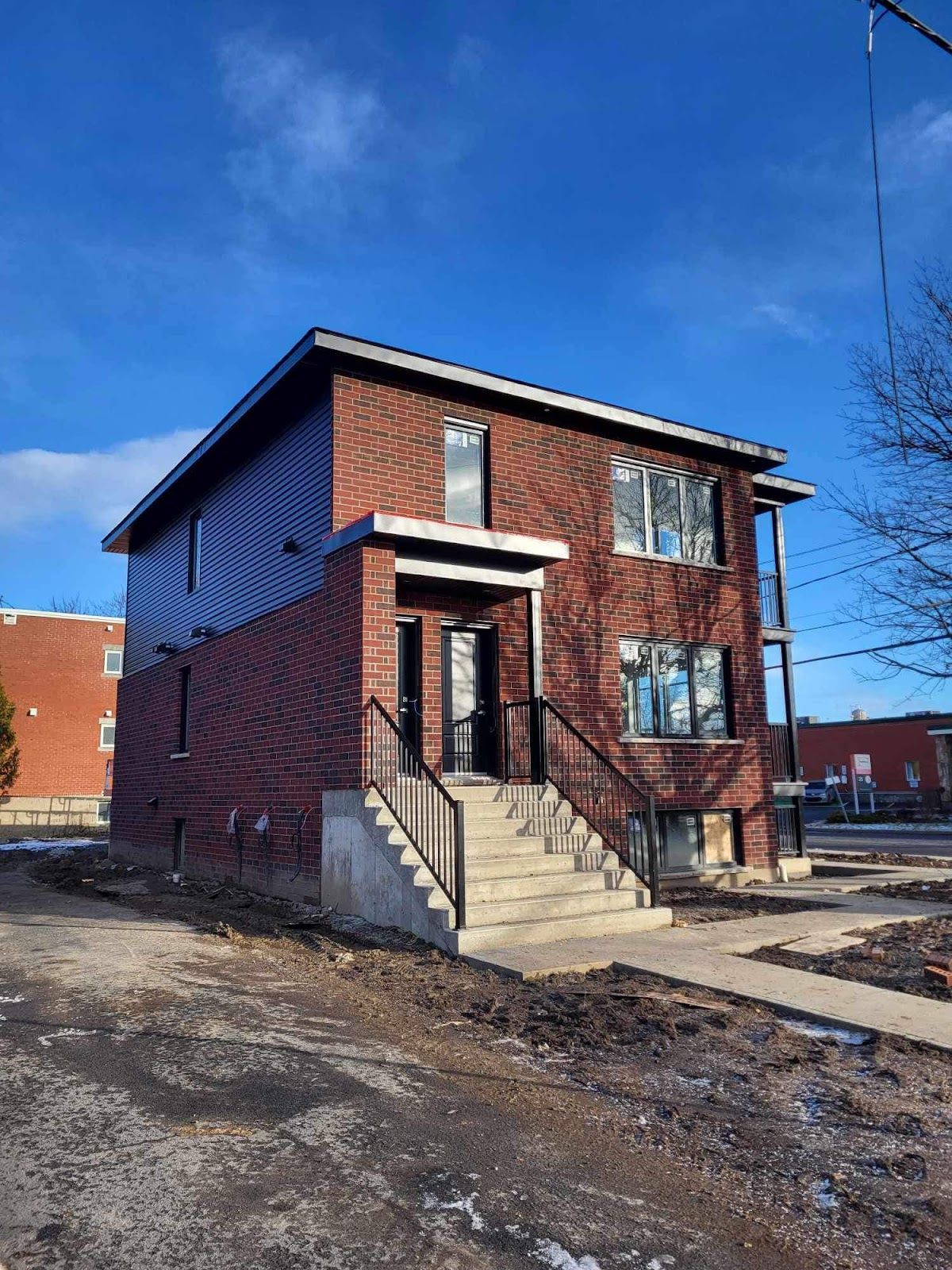 Une maison en brique avec des escaliers menant à la porte d'entrée.