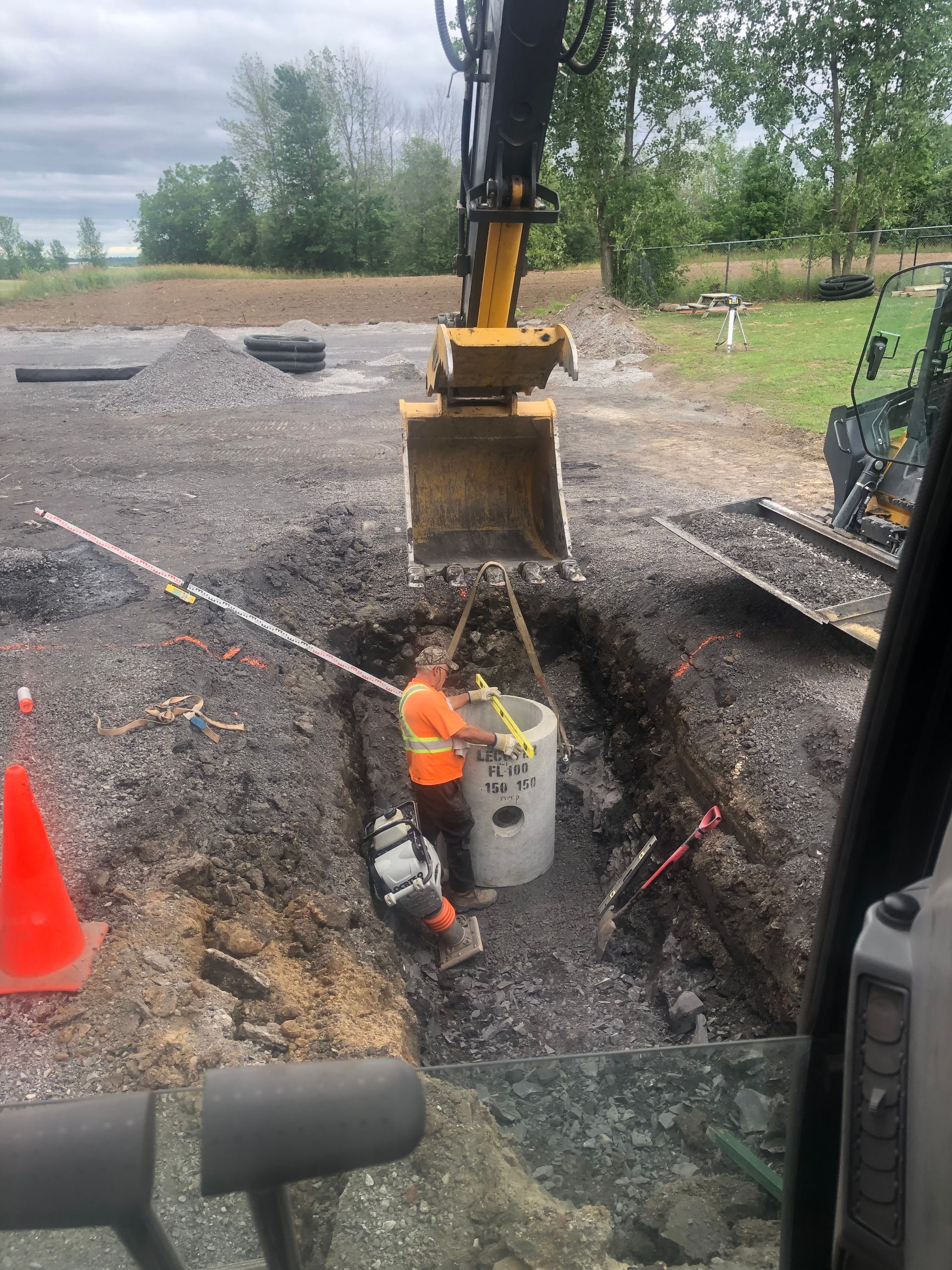 Un homme creuse un trou dans le sol avec un bulldozer.