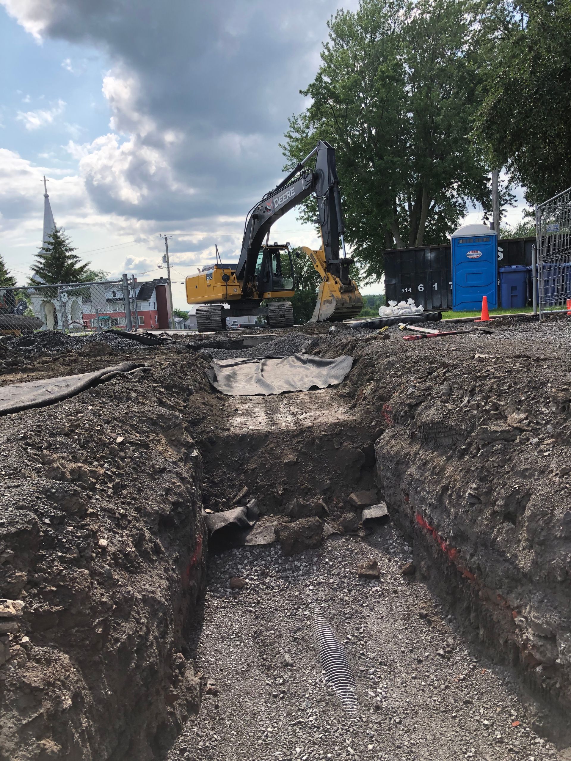 Une grande pelle jaune creuse un trou dans la terre.
