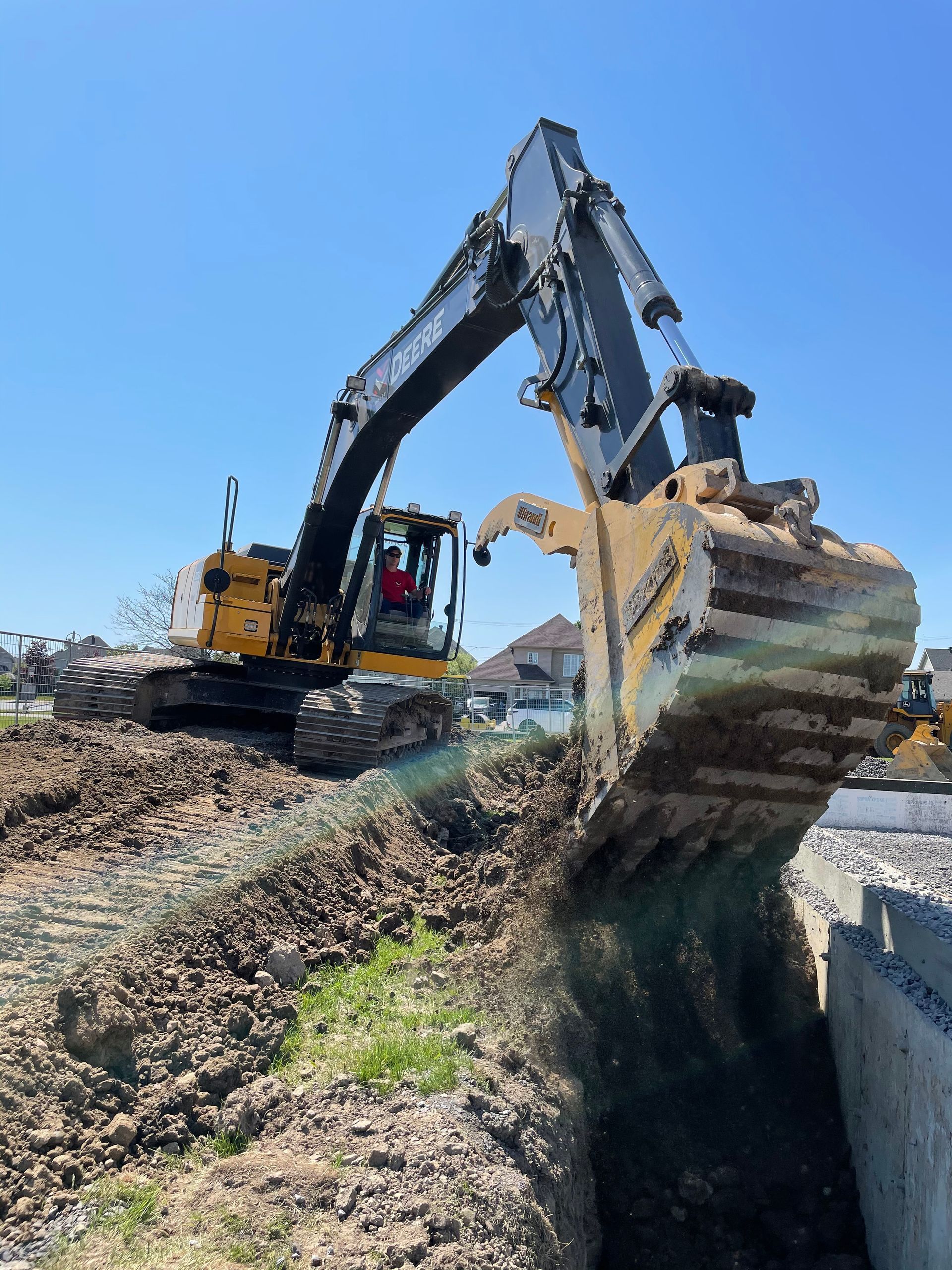 Une grande excavatrice creuse un trou dans le sol.