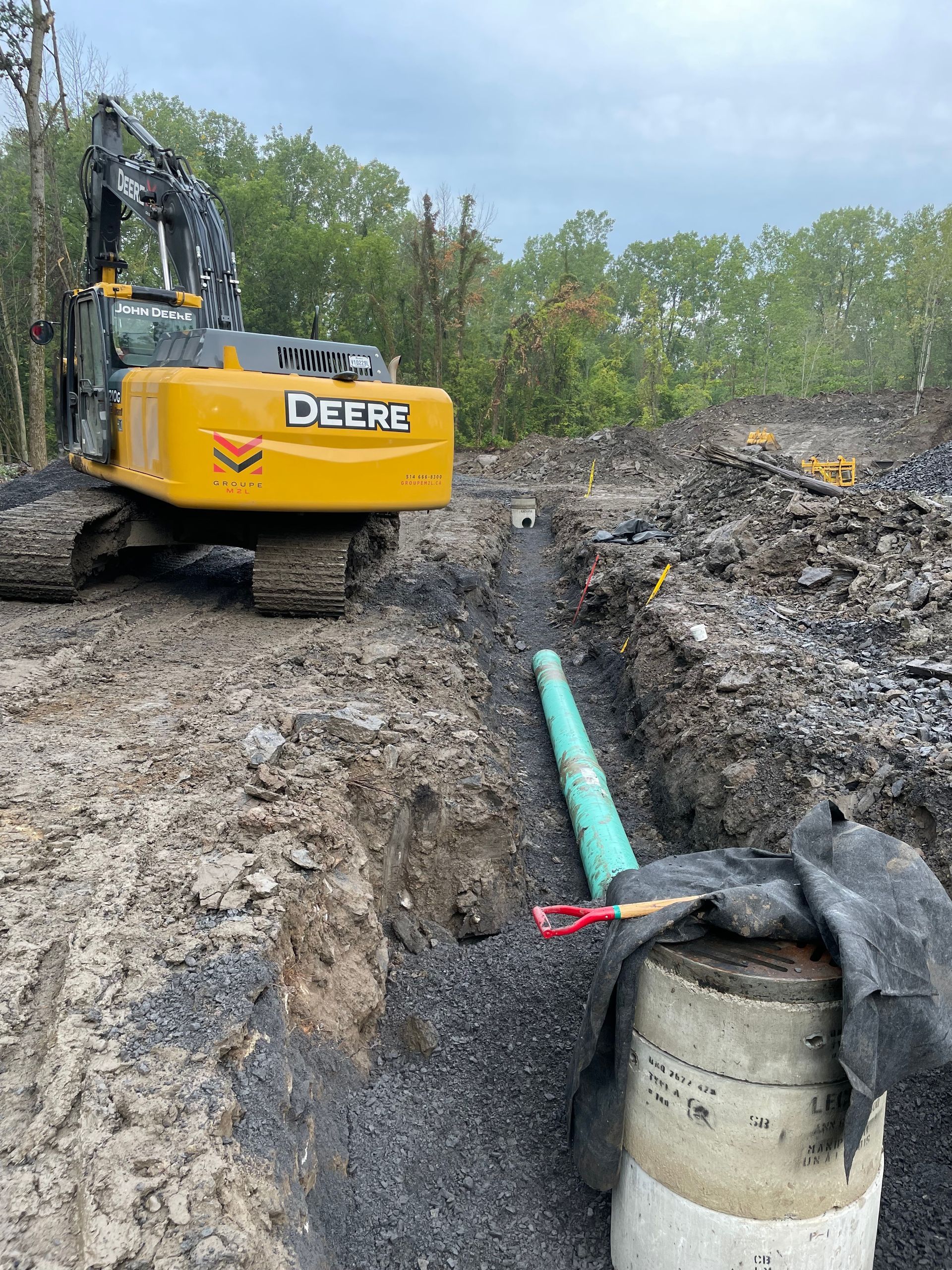Une grande pelle jaune creuse un trou dans la terre.
