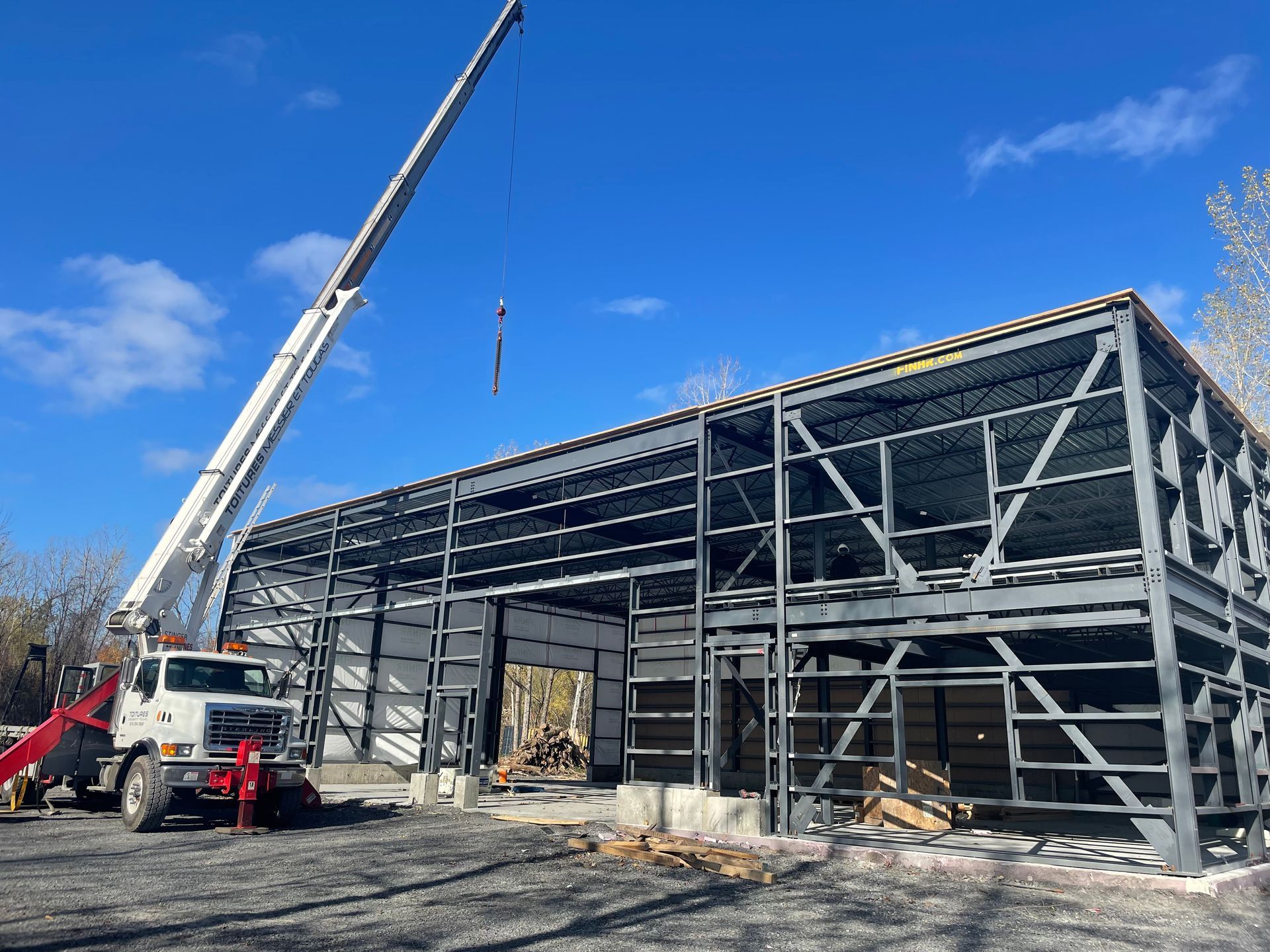 Un gros camion blanc est garé devant un immeuble en construction.