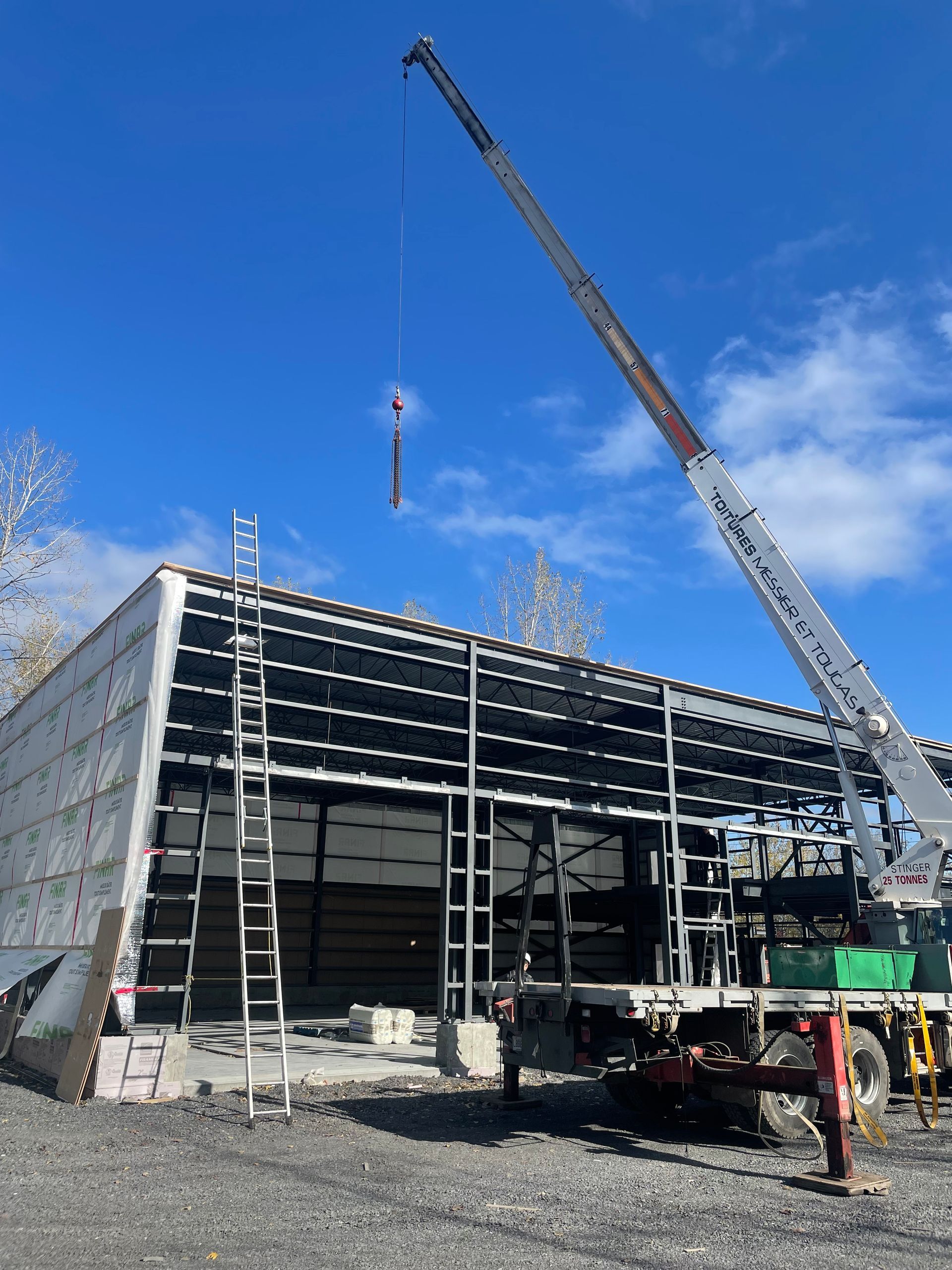 Une grande grue travaille sur un bâtiment en construction