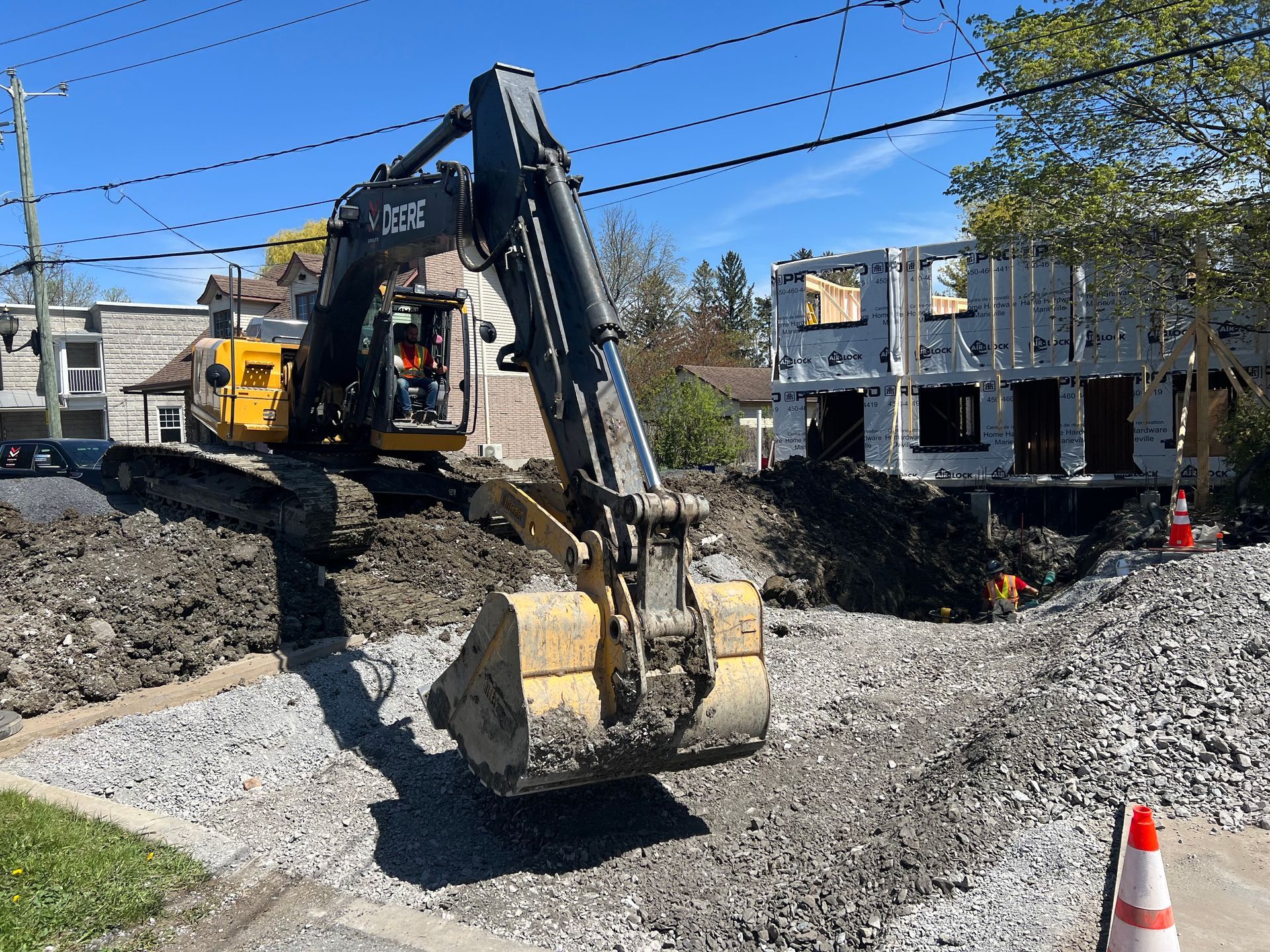 Une grande pelle jaune creuse un trou dans le sol.